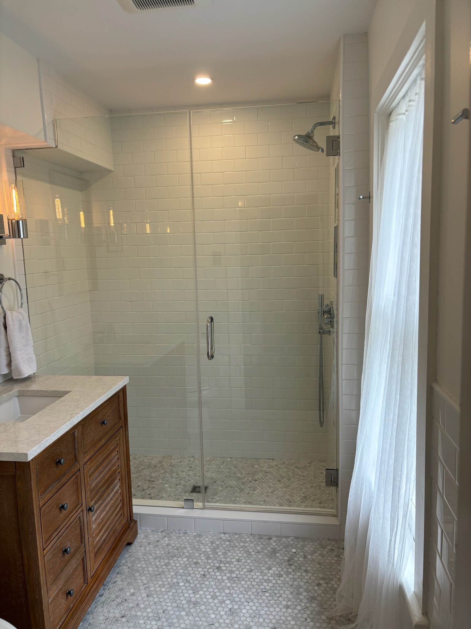 Renovated bathroom — marble penny tile, glass shower