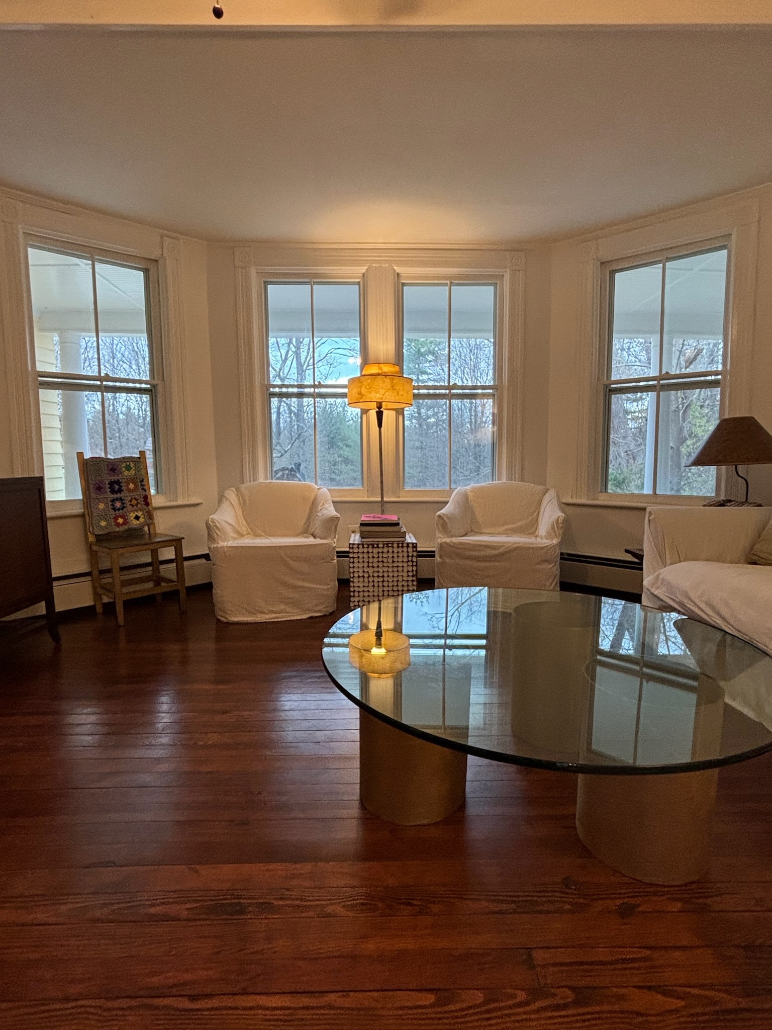 Living room — glass coffee table, bay windows, upright piano