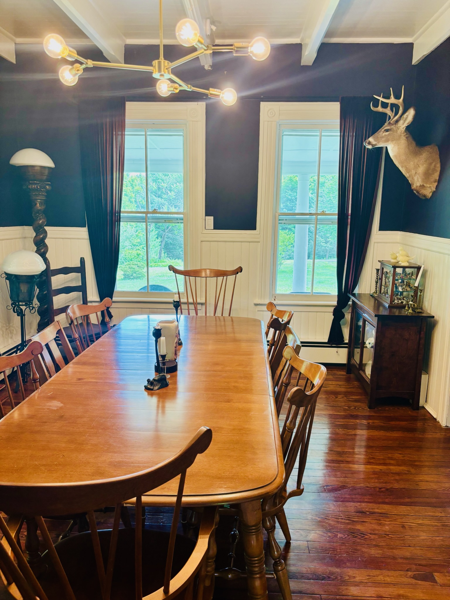 Dining room detail showing brass sputnik chandelier above farm table