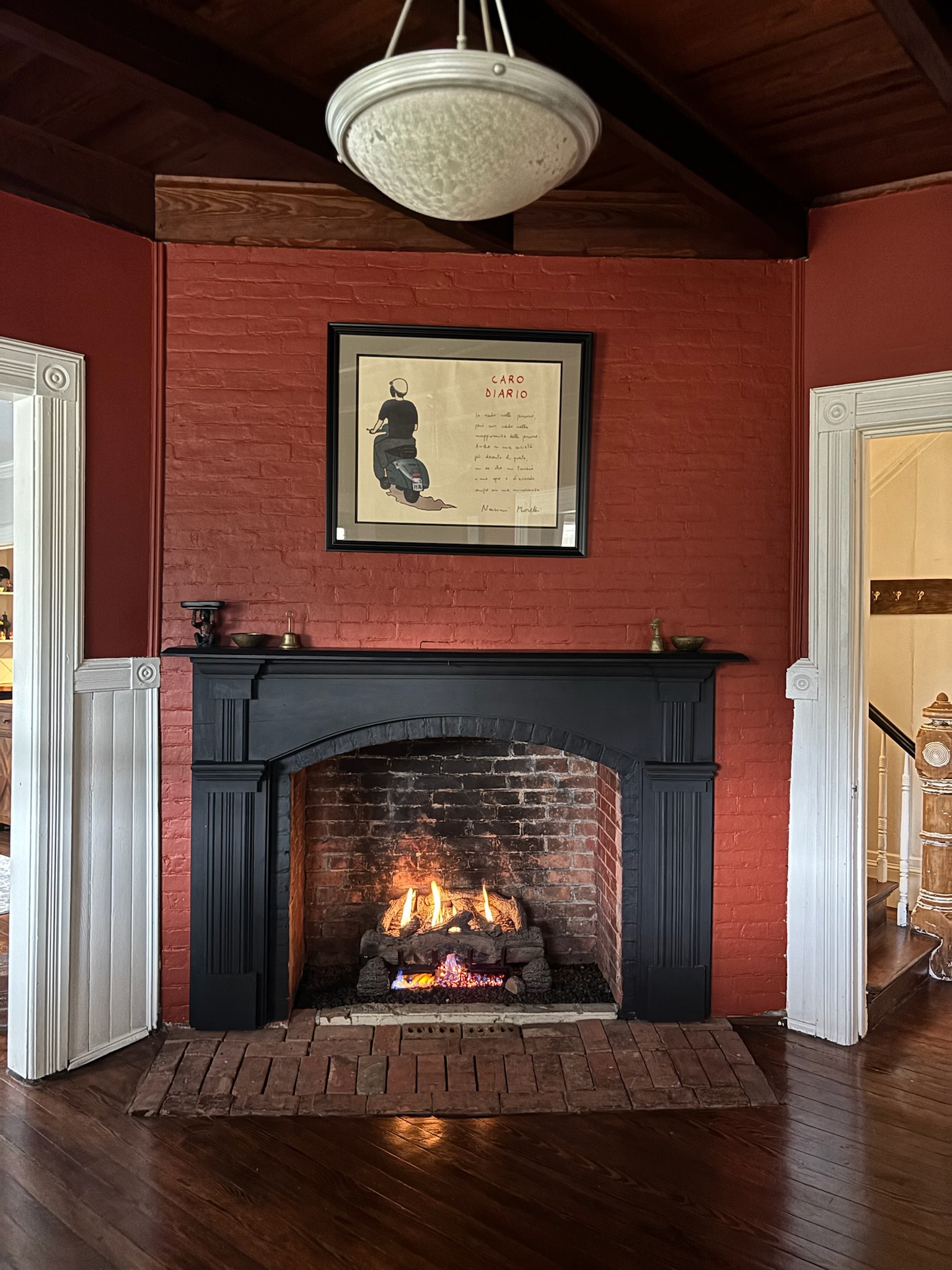 Entry hall staircase base with original carved newel post, turned balusters, and white paneled wainscoting
