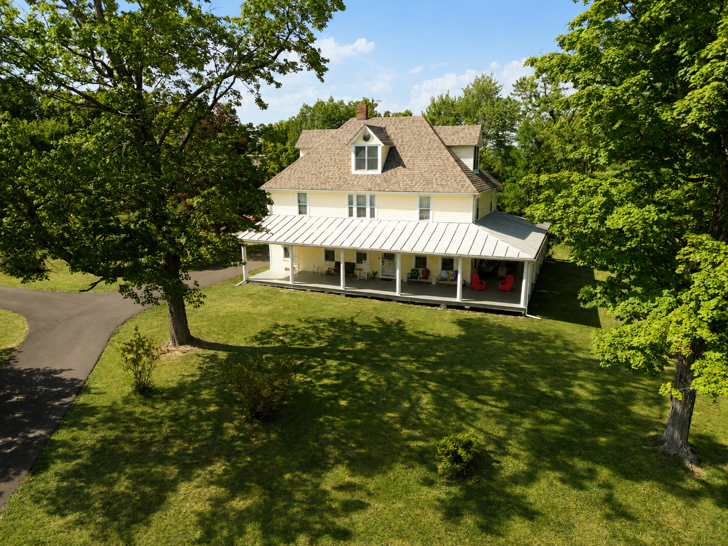 Aerial view of the full farmhouse and grounds with mountains in the distance