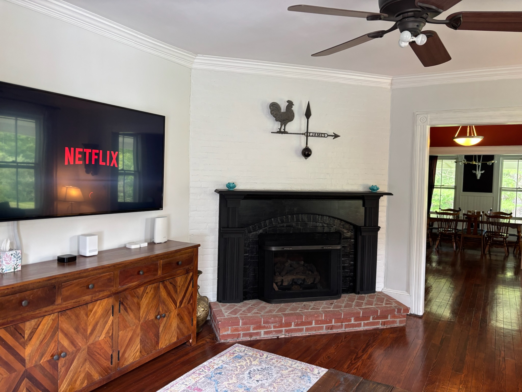 Fireplace living room with original crown molding, hardwood floors, and antique furnishings