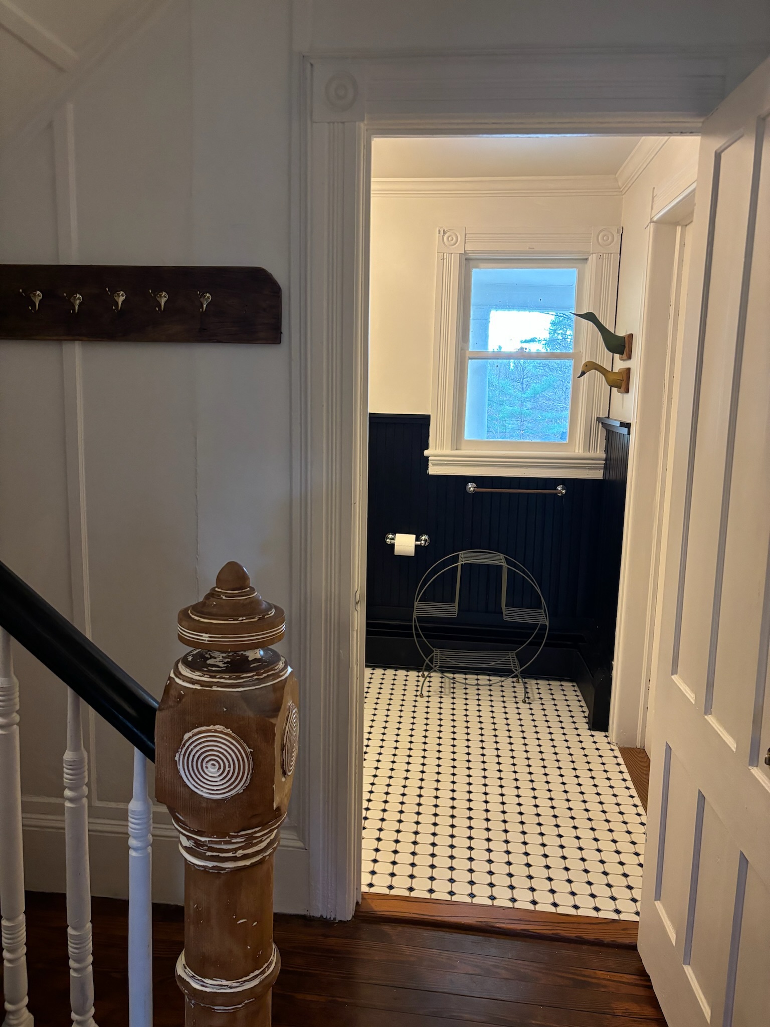 First floor bathroom vanity with carved wood mirror and vintage fixtures
