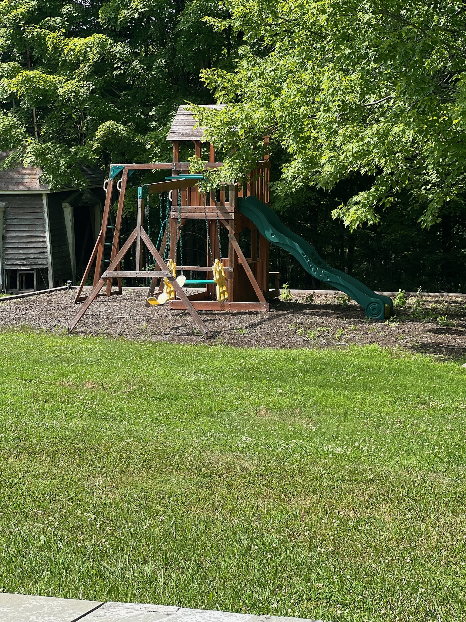 The children's play set with swing and slide on the lawn