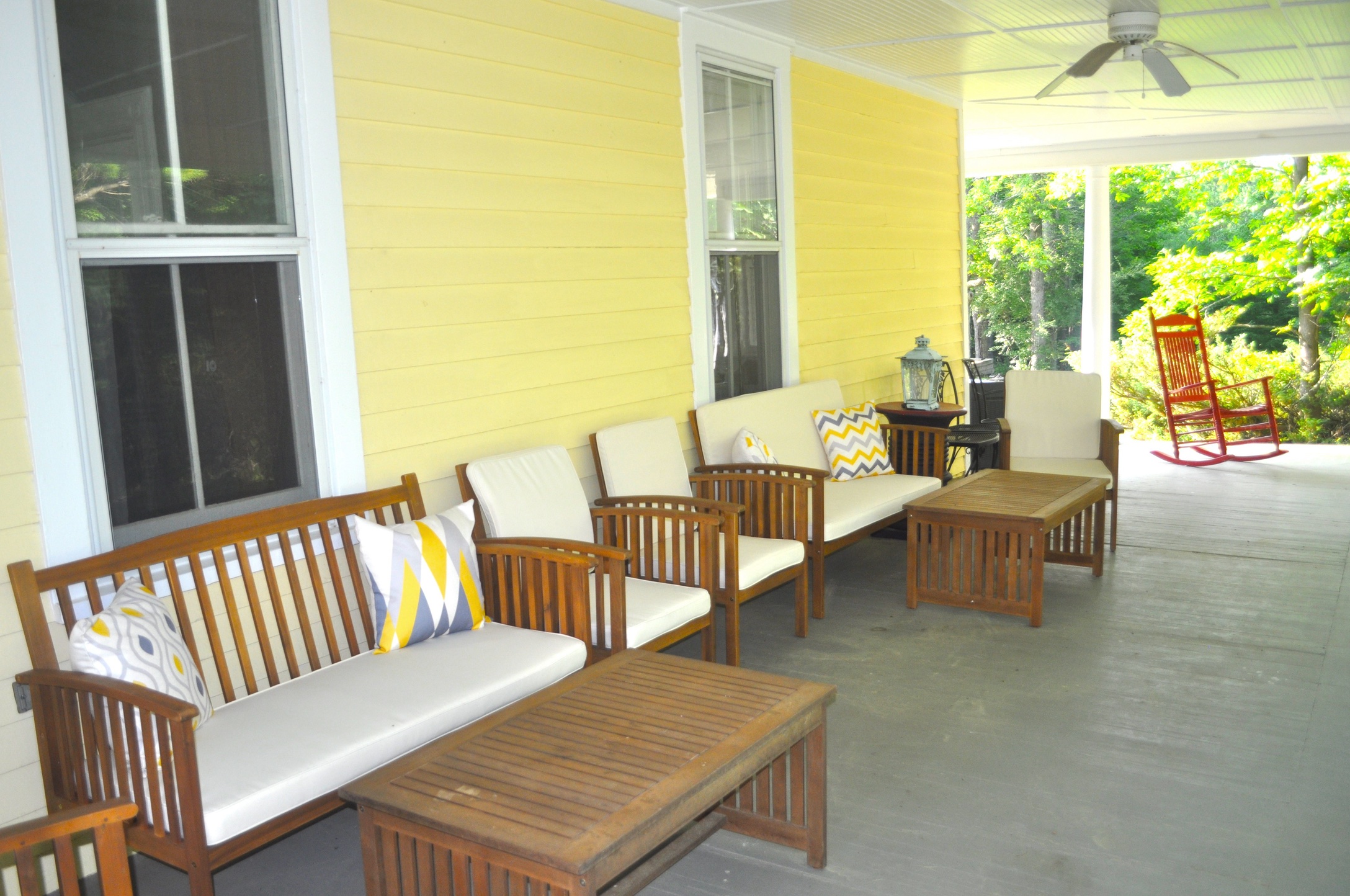 The wrap-around porch — teak seating, ceiling fans, summer afternoons