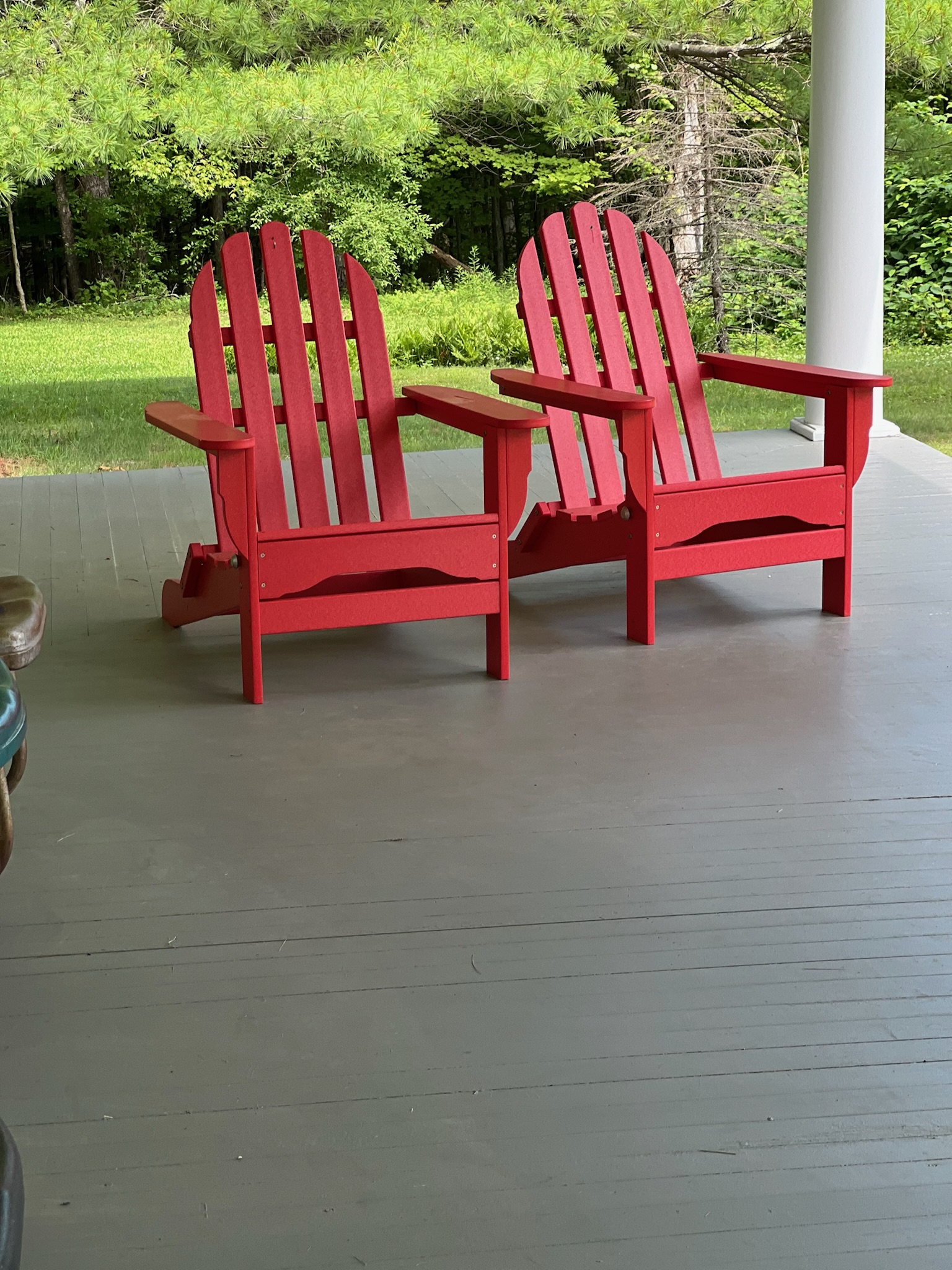 Red Adirondack chairs on the wrap-around porch
