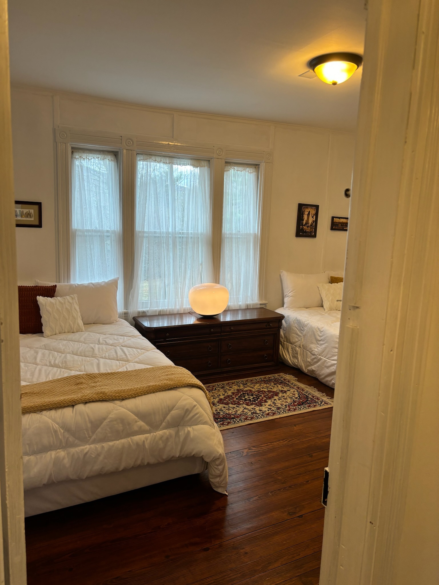 Bedroom five detail showing original millwork window surround and hardwood floors